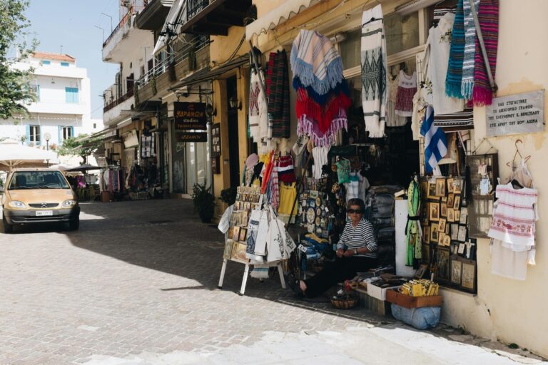 Charming street market in Chania, Greece, with vibrant textiles and local crafts on display.